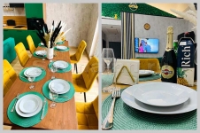 Коттедж Графит-Хаус - кухня-гостинная с банкетным столом, красивая посуда, холодильник, плита, микроволновка, тостер, чайник, столовые приборы